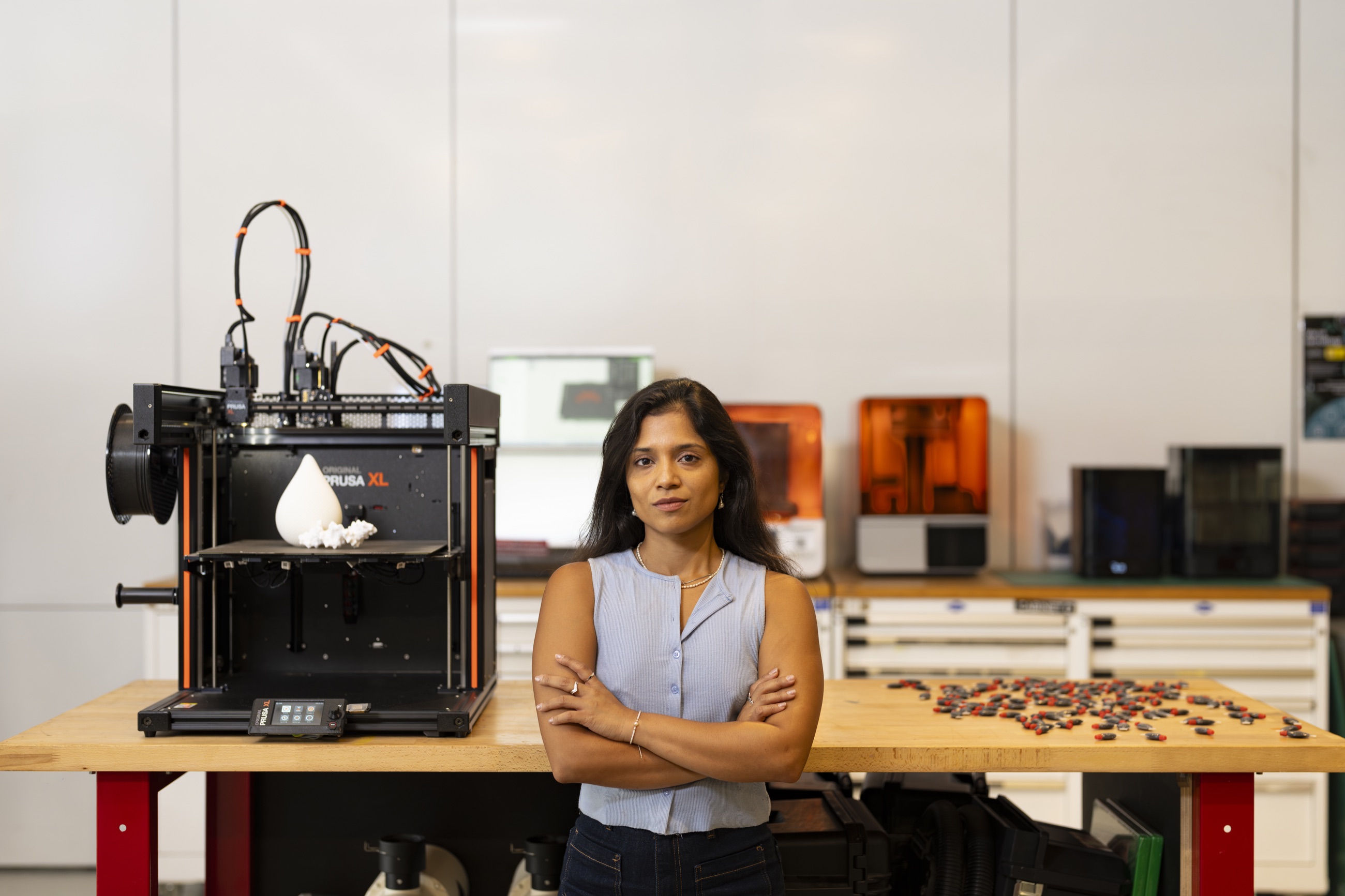 Rashika Sood in her fabrication studio beside a 3D printer